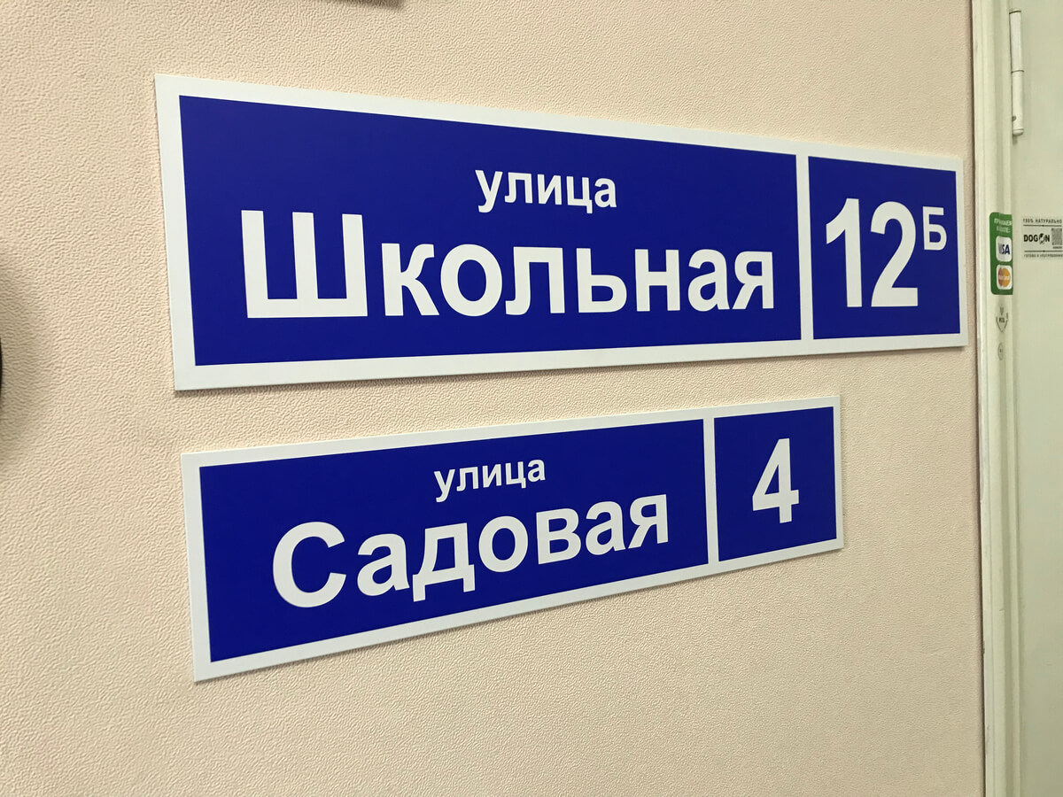 Две синие адресные таблички на стене, Школьная и Садовая