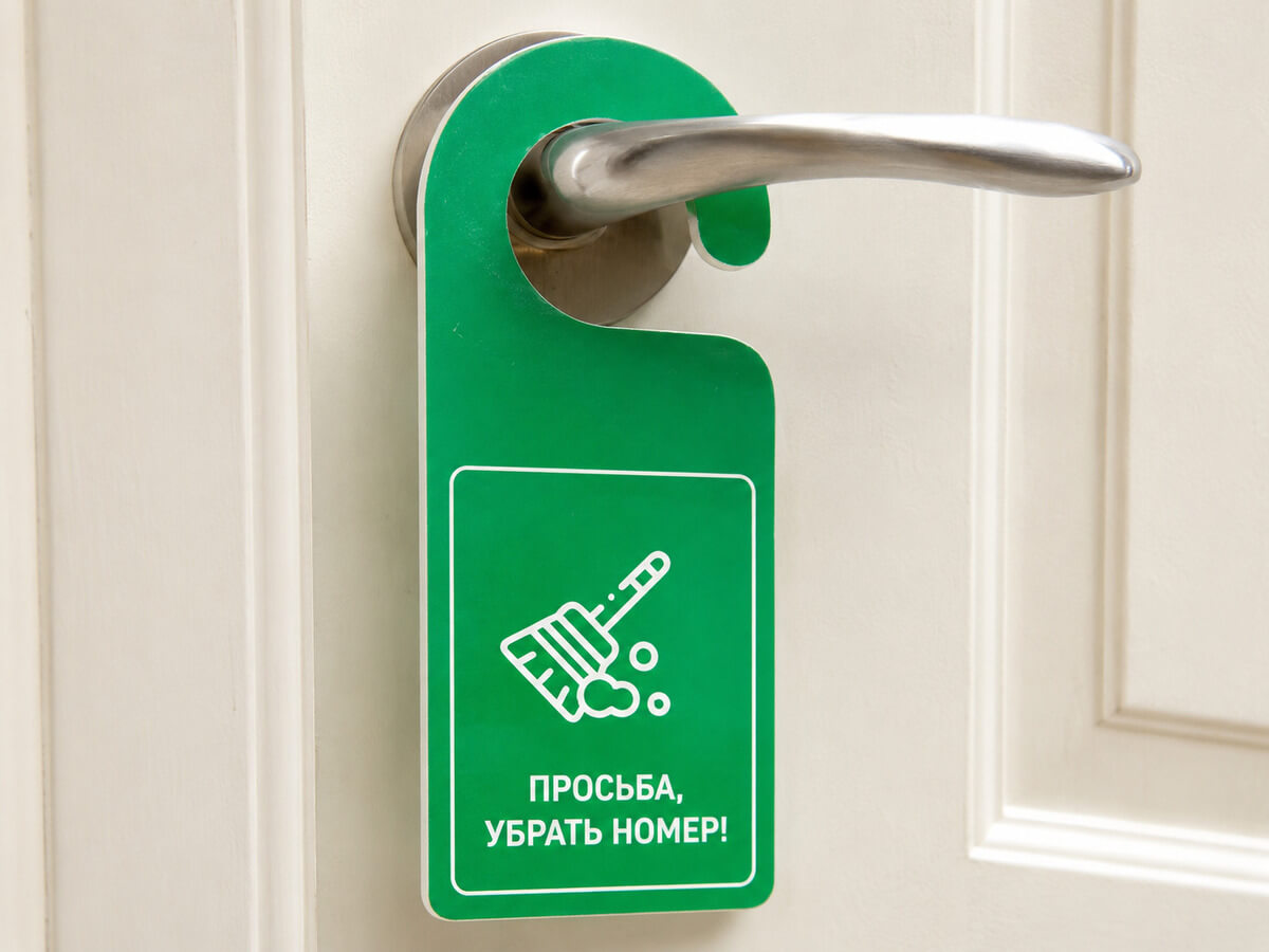 Зелёный дорхенгер на ручке двери с просьбой убрать номер